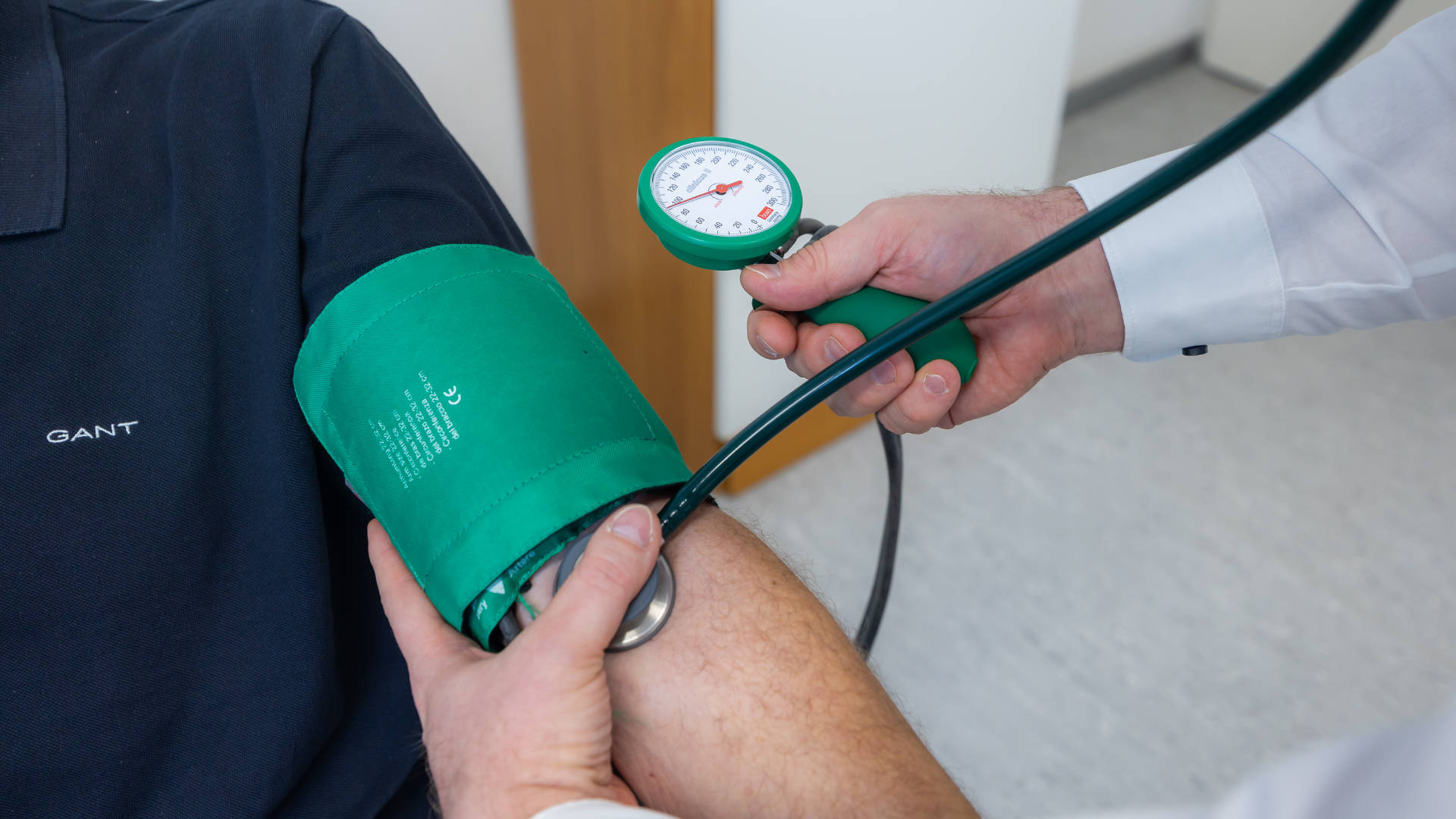Nahaufnahme Blutdruckmessung mit grünem Blutdruckmesser