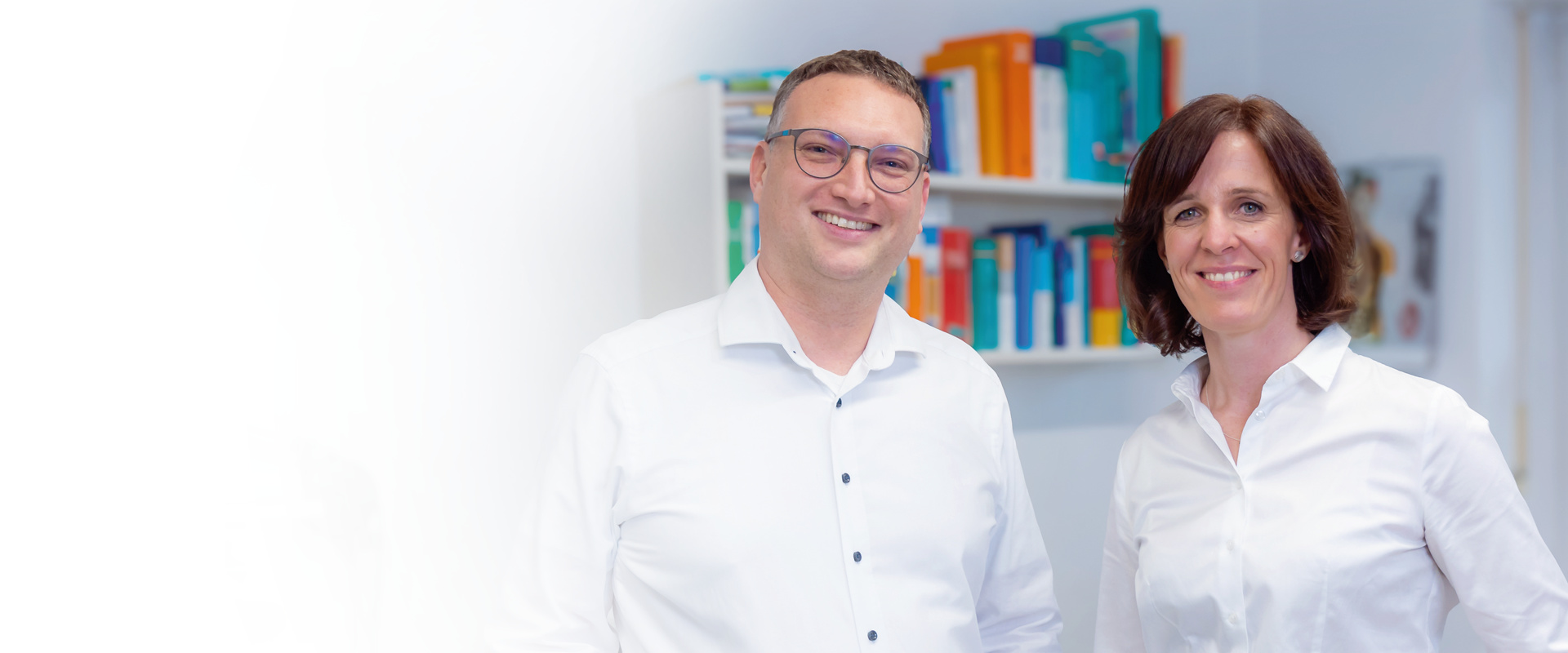 Dr. Matthias Hartmann und Dr. Carola Hummel Portrait nebeneinander im Sprechzimmer